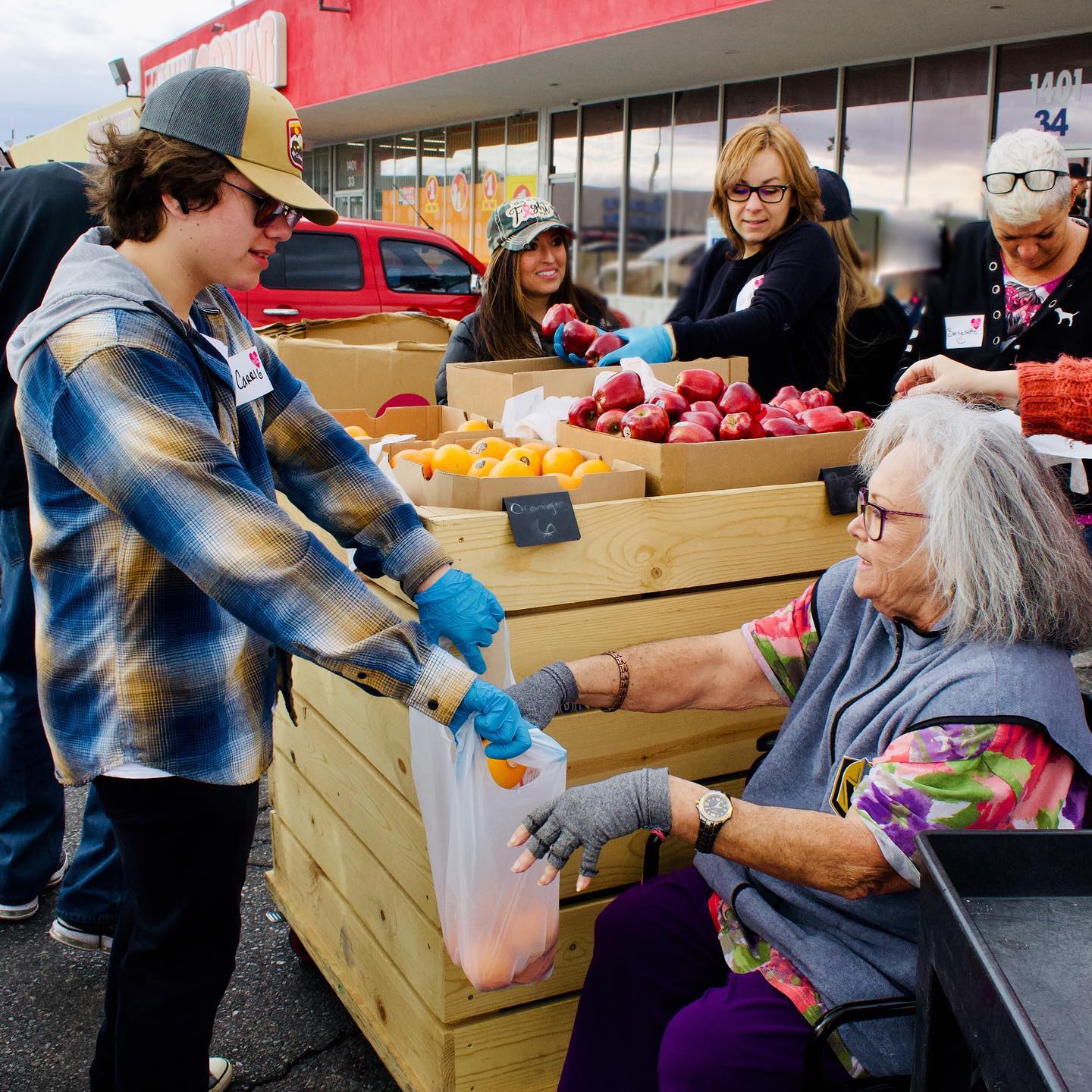 A woman handing out food to an older person.