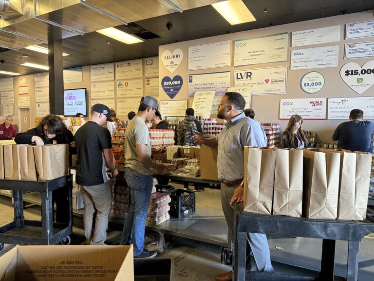 A group of people standing around boxes in a room.
