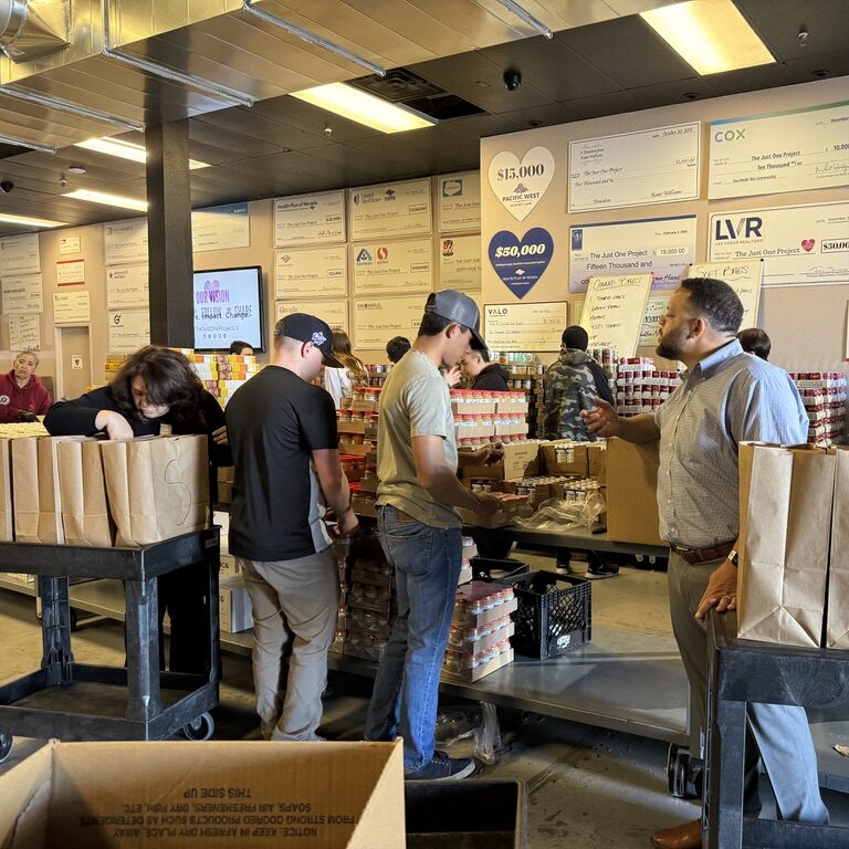 A group of people standing around boxes in a room.