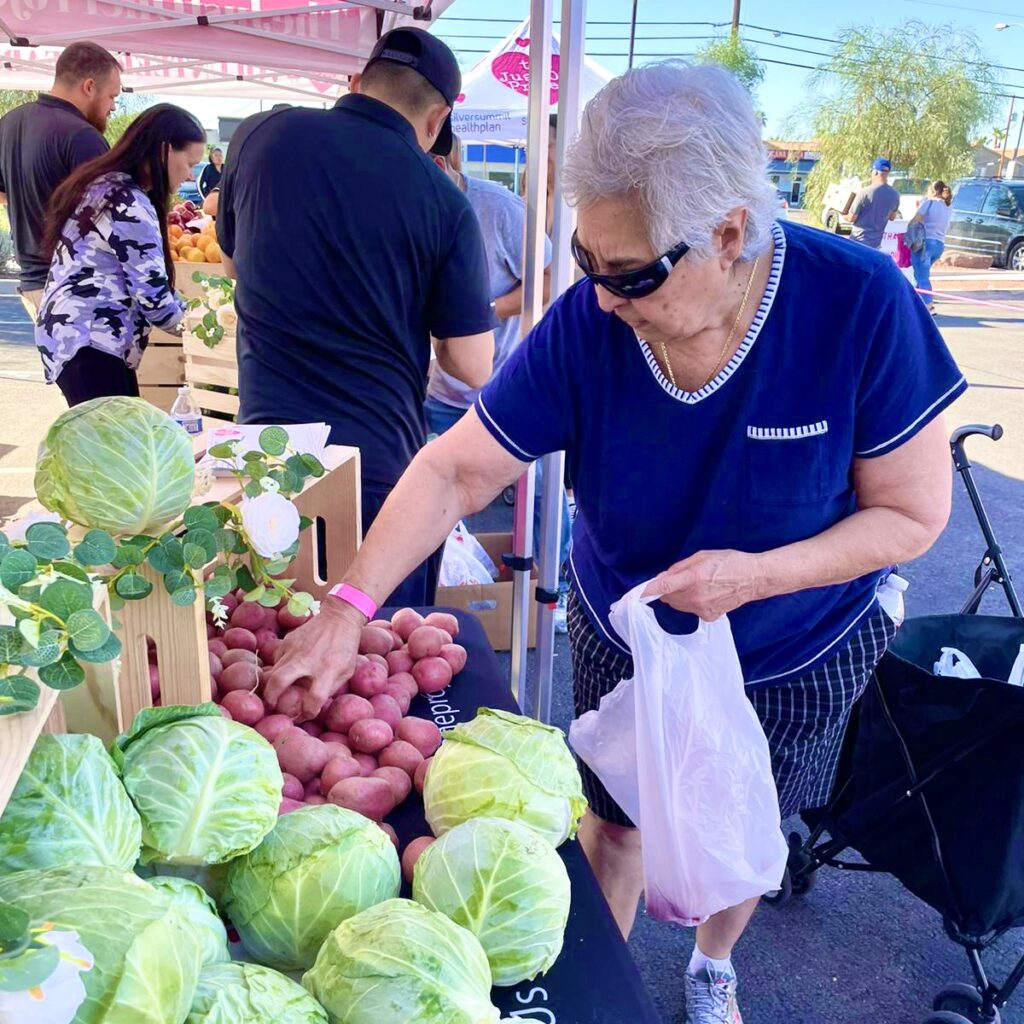 A woman is shopping at an outdoor market.