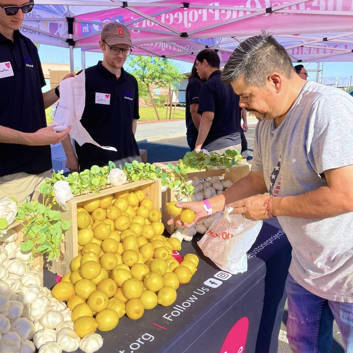 A man cutting up fruit at an outdoor market.