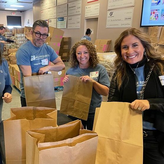 A group of people holding brown bags in front of boxes.