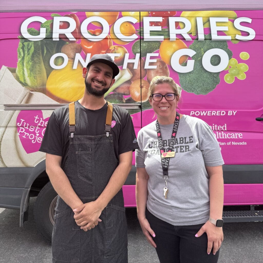 A man and woman standing in front of a food truck.