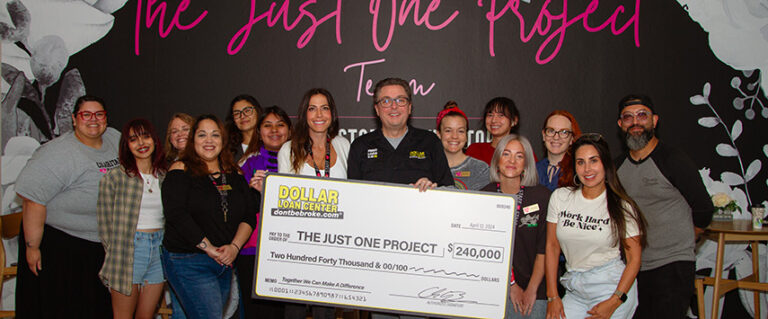 A group of people standing around a large check.