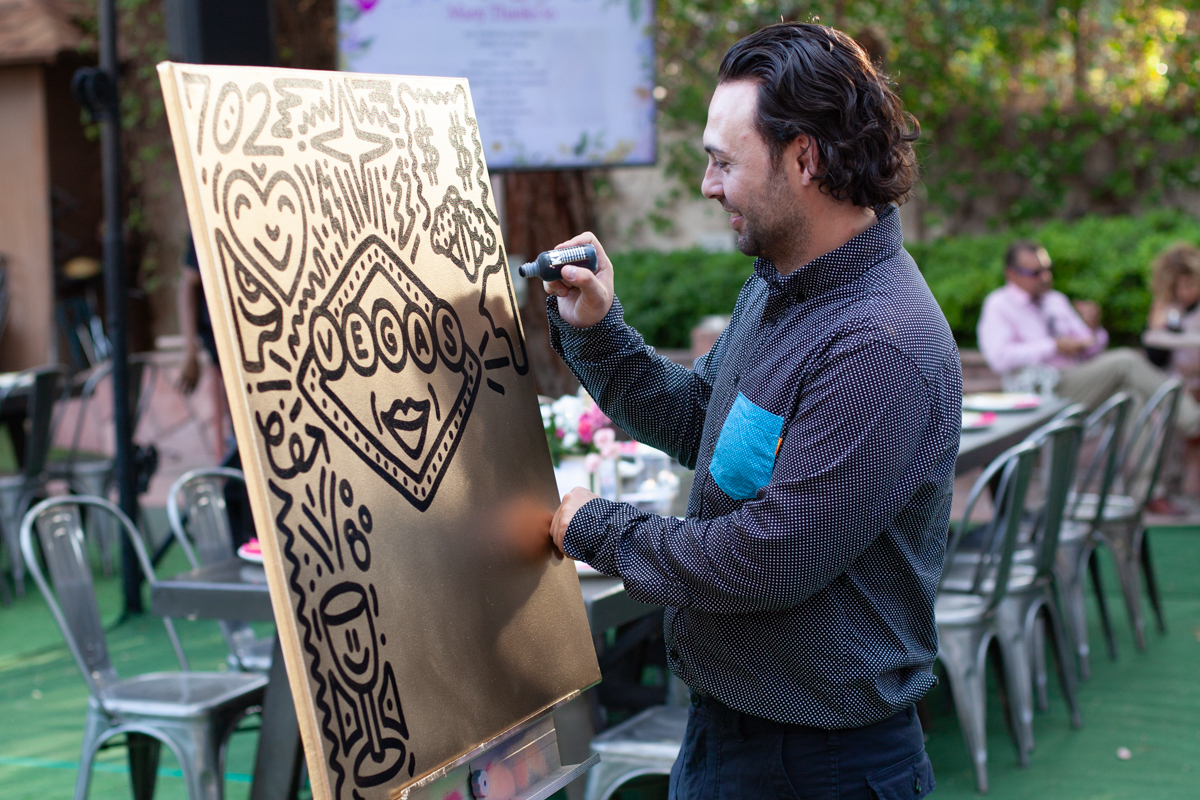 A man painting with black paint on canvas.