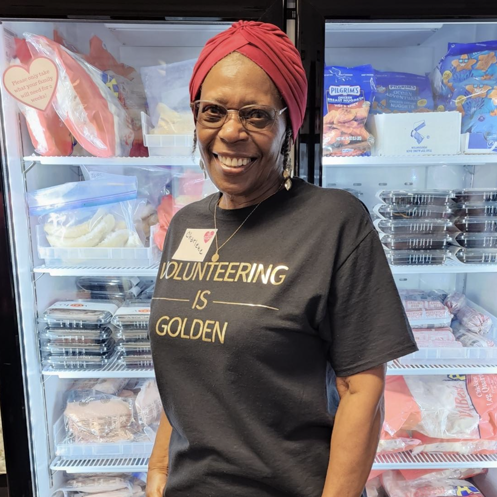 A woman standing in front of an open freezer.