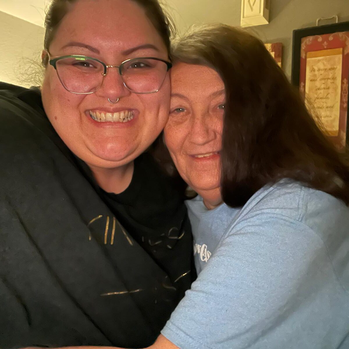 Two women hugging each other in a restaurant.