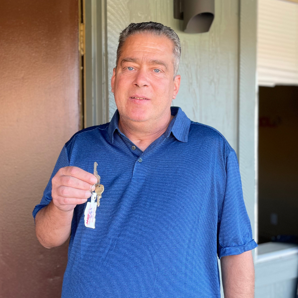 A man holding a key in his hand.