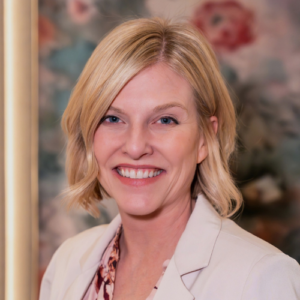 A woman with blonde hair and a white jacket.