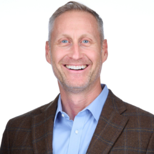 A man in a suit and tie smiling for the camera.