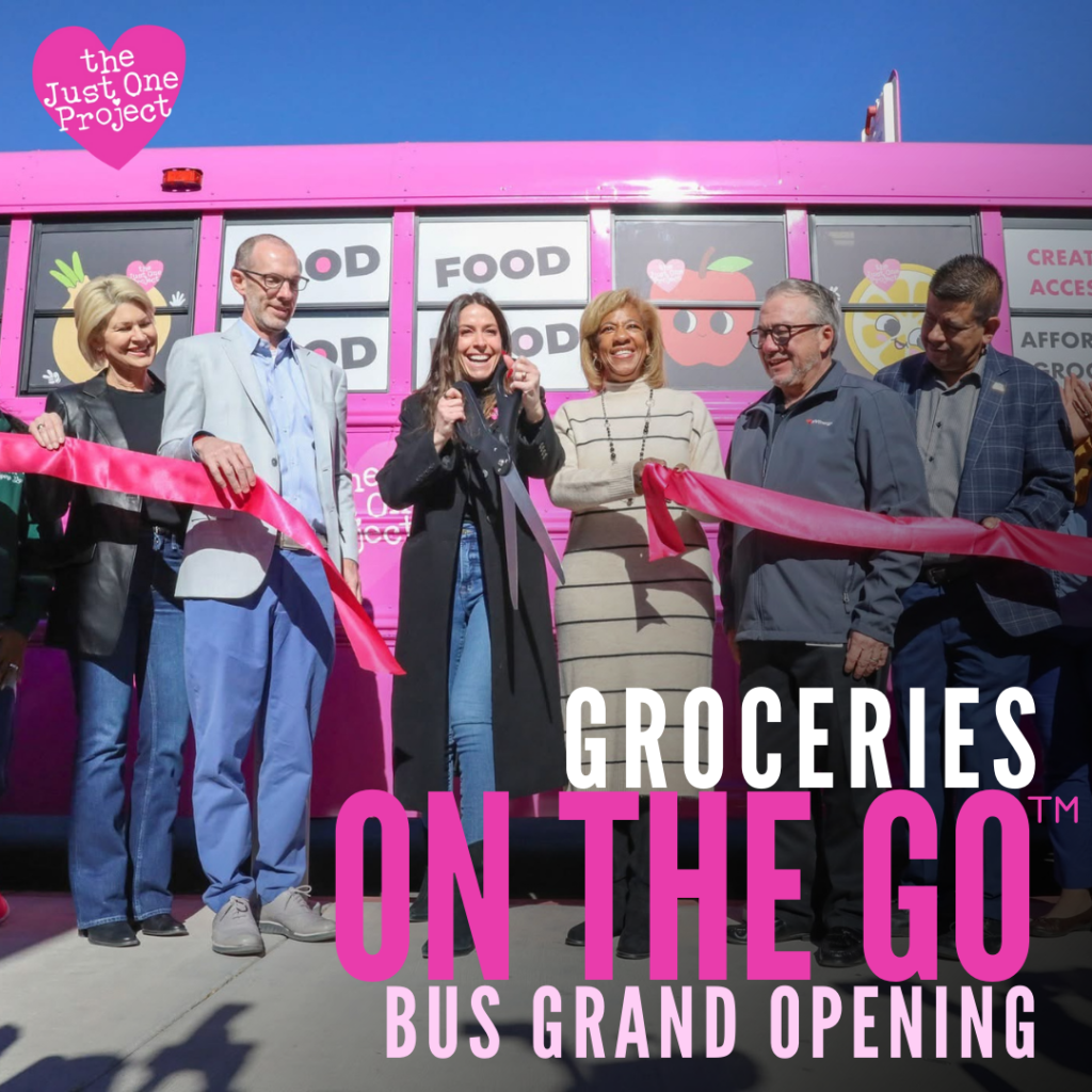 A group of people standing in front of a pink bus.