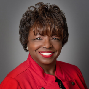 A woman in red jacket smiling for the camera.
