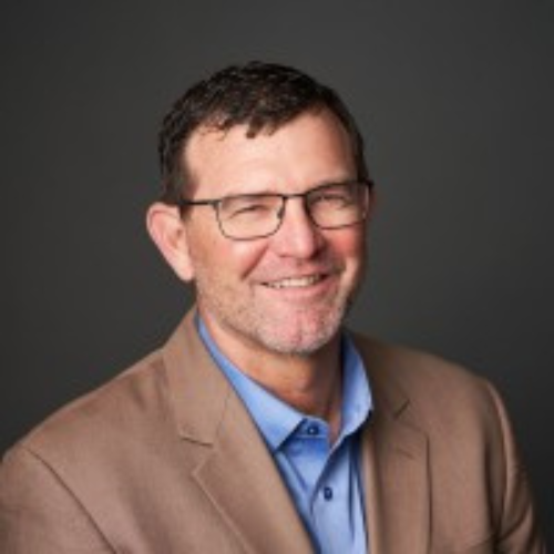 A man in glasses and a brown jacket