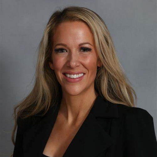 A woman in black jacket smiling for the camera.