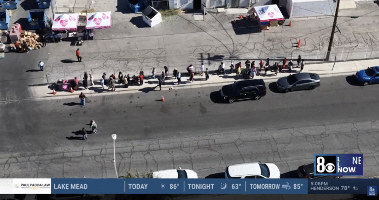 Cars line up at The Just One Project’s Las Vegas distribution site as volunteers prepare emergency grocery boxes in response to the SNAP funding lapse, featured in a News 8 YouTube report.