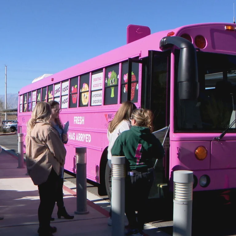 The Just One Project’s pink Groceries on the Go mobile market bus parked at a community site, bringing fresh produce and groceries to Southern Nevada neighborhoods.